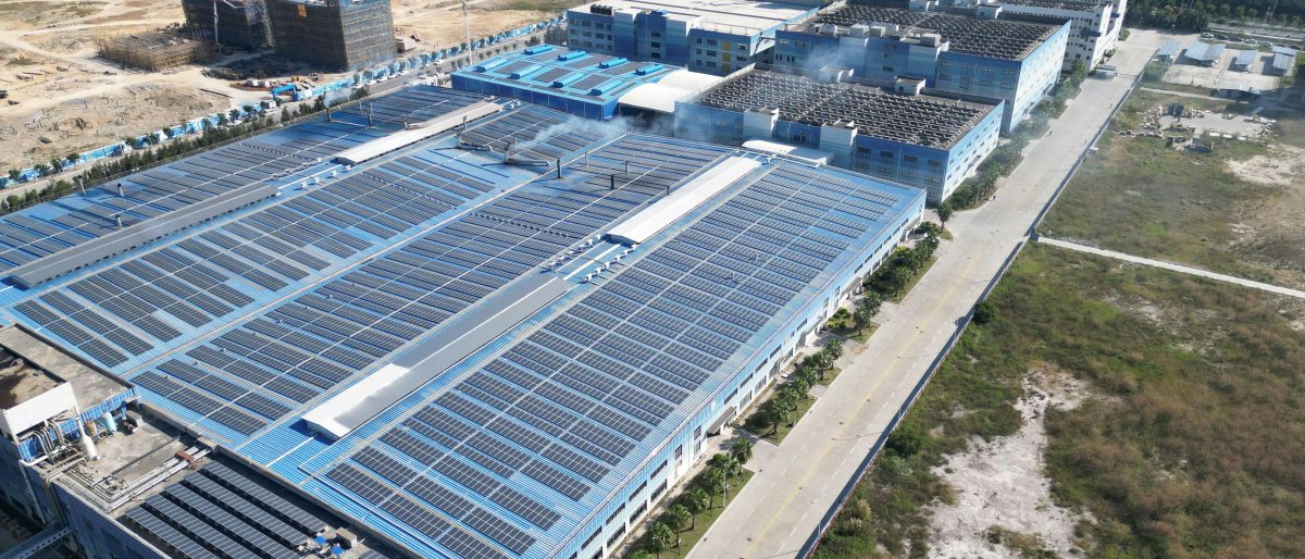 Aerial photograph showcasing large solar panels installed on an industrial building complex.